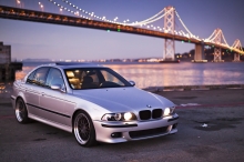 Серебристый BMW 5 series напротив моста